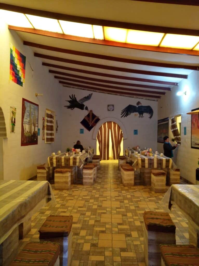La sala da pranzo dell'Hotel Salt, sulla parete sono appesi i condor andini e il Wiphala di Qullasuyu, un simbolo tradizionale delle popolazioni indigene delle Ande.